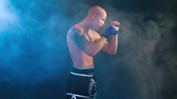 Muscular kickbox ou muay thai lutador perfurando na fumaça . — Vídeo de Stock