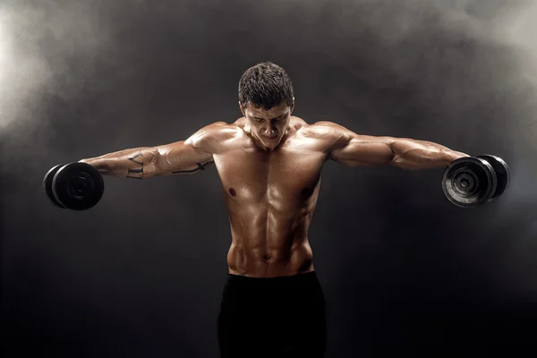 Topless muscular man doing exercise with dumbbells — Stock Photo, Image