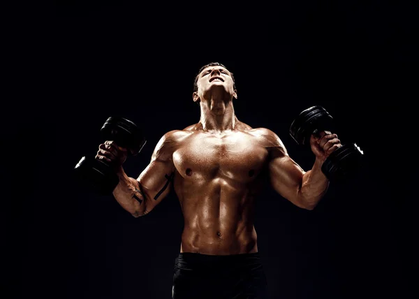 Hombre musculoso concentrado haciendo ejercicio con pesas — Foto de Stock