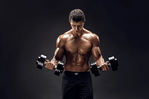Hombre musculoso concentrado haciendo ejercicio con pesas — Foto de Stock