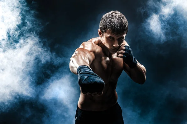 Kickbox musculaire ou muay thai boxeur poinçonnage en fumée . — Photo