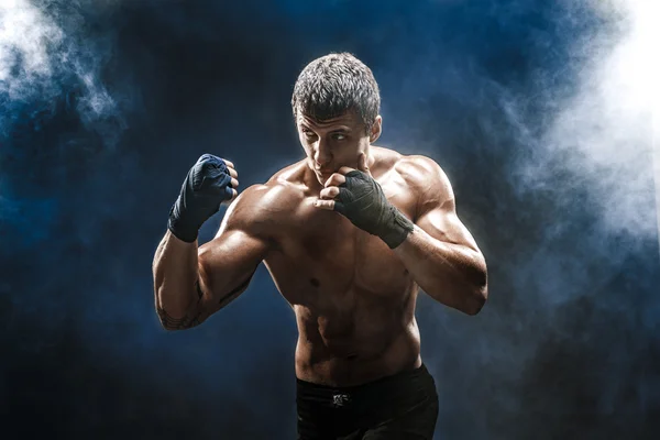 Muscular kick-box ou muay thai lutador de perfuração em fumaça . — Fotografia de Stock