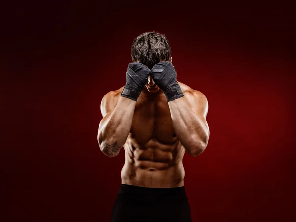 Сильний м'язовий боєць ховається обличчям від камери — стокове фото