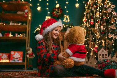 Cutel 'in portresi küçük kız Taddy ayısıyla oynuyor, yeni yıl tatili konsepti.