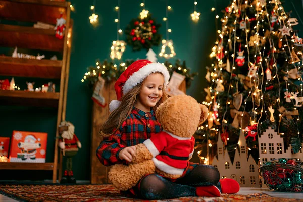 Портрет маленької дівчинки, яка грає з Тадді ведмедем, концепція новорічних свят — стокове фото