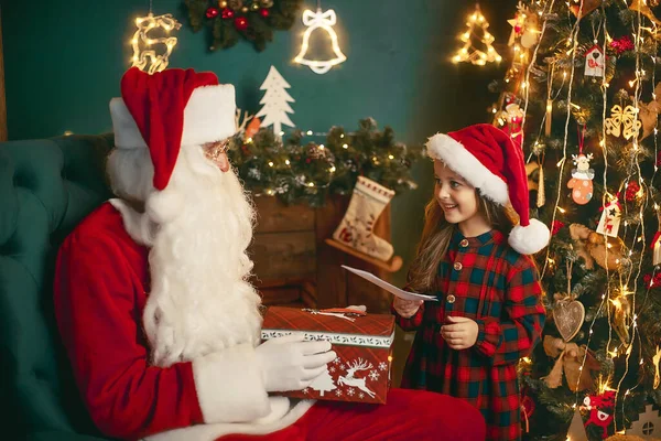 Веселого Різдва, маленька донечко, яка дає листа Санті Клаусу. — стокове фото