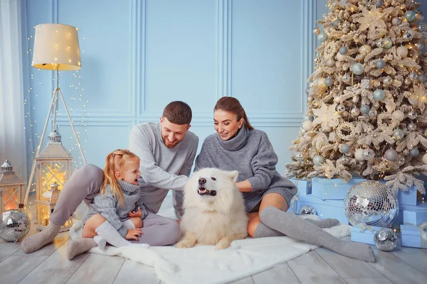 Happy family with dog near by Christmas tree