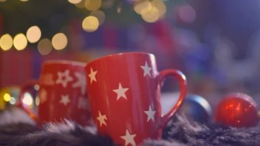 Yakın plan iki bardak sıcak, kırmızı, aromatik içecek ve bulanık noel arkaplanı.