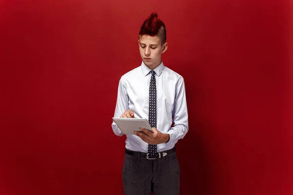 Punk elegante com tablet contra de fundo vermelho — Fotografia de Stock