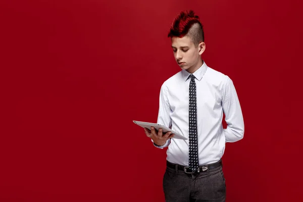 Elegante punk con tablet sobre fondo rojo —  Fotos de Stock