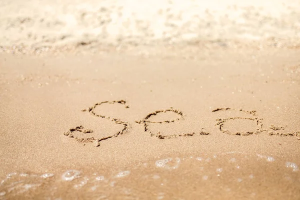 Palabra manuscrita del mar en la costa de arena. Maravillosas palabras en arena de playa. Concepto de idea de amor — Foto de Stock