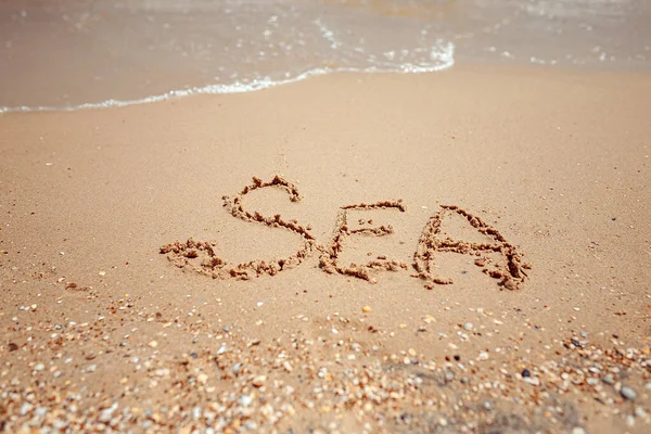 Palabra manuscrita del mar en la costa de arena. Maravillosas palabras en arena de playa. Concepto de idea de amor — Foto de Stock