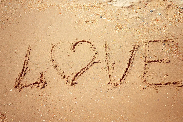 Рукописное любовное слово на песчаном побережье. Замечательные слова на песке. Идея любви — стоковое фото