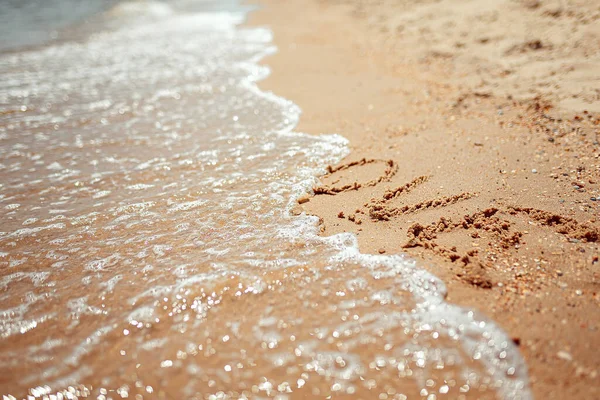 Palabra de amor escrita a mano en la costa de arena. Maravillosas palabras en arena de playa. Concepto de idea de amor — Foto de Stock