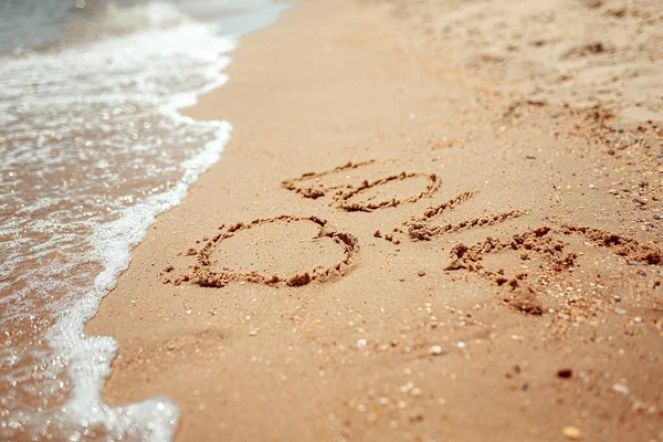 Parola d'amore manoscritta sulla costa sabbiosa. Parole meravigliose sulla sabbia della spiaggia. Idea amore concetto — Foto Stock