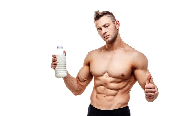 Láhev mléka v ruce, muž se sportovním tělem pózující na bílém pozadí — Stock fotografie