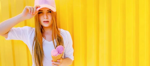 Outdoor mode portret van jonge hipster meisje met ijs op gele muur achtergrond — Stockfoto