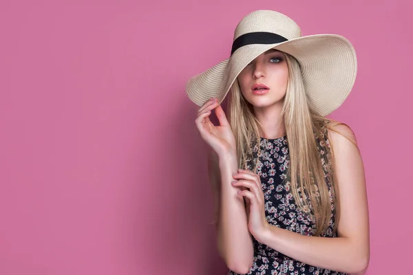 Schönheit Foto von attraktiven sinnlichen Frau trägt Strohhut, posiert auf rosa Studiohintergrund. Mädchen mit Glamour-Make-up — Stockfoto