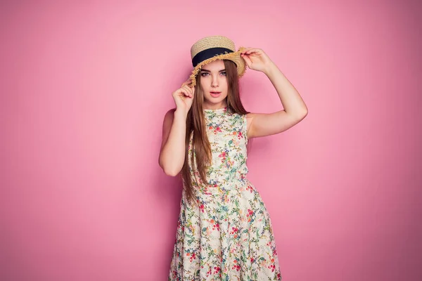 Menina Winsome em vestido romântico com impressão de flores e chapéu de palha posando sorrindo muito em um fundo roxo — Fotografia de Stock