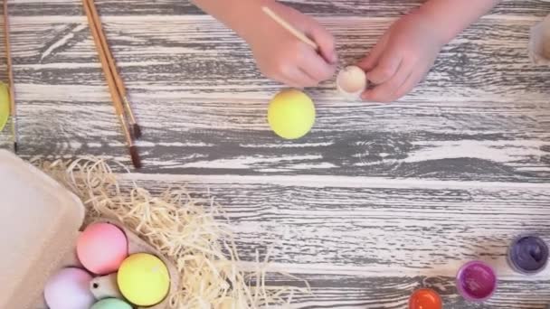 孩子们的手在用油漆和刷子给复活节彩蛋上色.复活节准备工作。孩子DIY创造力 — 图库视频影像