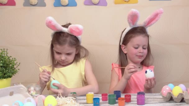 Happy easter. Two sisters painting Easter eggs. Happy family children preparing for Easter. Cute little child girl wearing bunny ears on Easter day — Stock Video