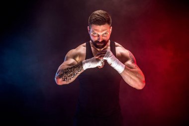 Sporcu Muay Thai boksörü siyah arka planda dumanla dövüşüyor. Spor konsepti