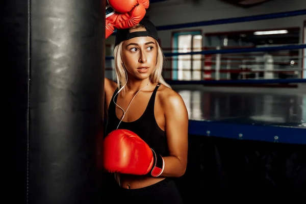 Mooie vrouw met de rode bokshandschoenen. Aantrekkelijke vrouwelijke bokser training — Stockfoto