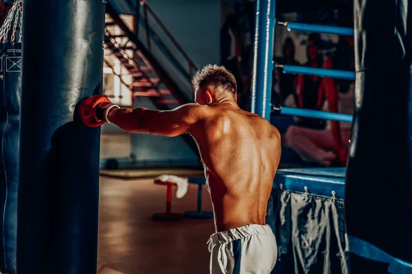 Boxer trénink na boxovací pytel v tělocvičně — Stock fotografie