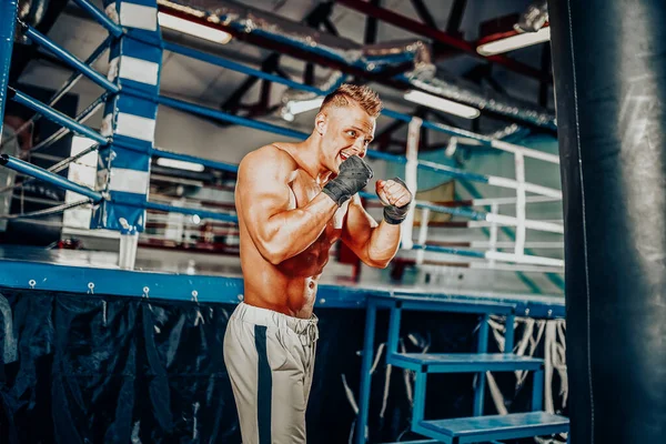 Boxer trénink na boxovací pytel v tělocvičně — Stock fotografie