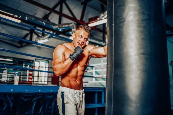 Bokser training op een bokszak in de sportschool — Stockfoto