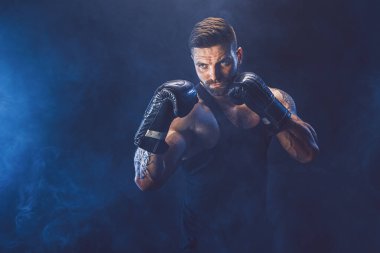 Sporcu boksör siyah arka planda gölgeli dövüşüyor. Uzayı kopyala Boks sporu konsepti.