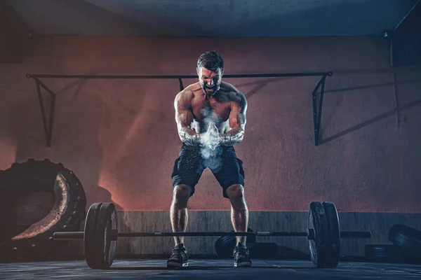 Hombre musculoso de fitness que se prepara para inmovilizar una barra sobre su cabeza en el moderno gimnasio. Entrenamiento funcional. Ejercicio arrebatado — Foto de Stock