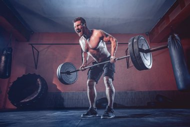 Spor salonunda egzersiz yapan kaslı bir adam. Güçlü erkek, çıplak karın kasları.