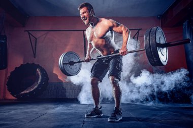 Spor salonunda egzersiz yapan kaslı bir adam. Güçlü erkek, çıplak karın kasları.