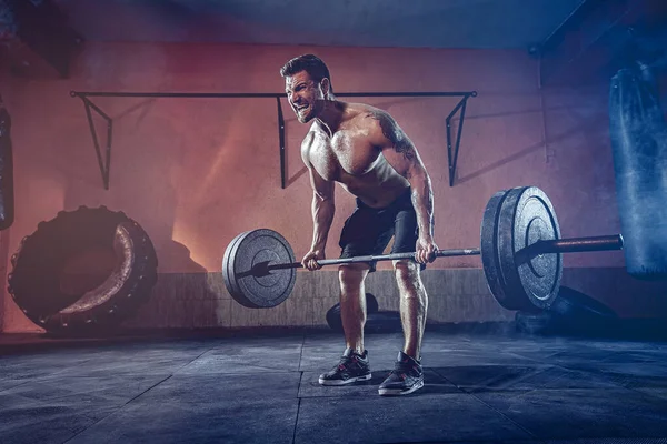 Hombre muscular haciendo ejercicio en el gimnasio haciendo ejercicios, fuertes abdominales masculinos desnudos del torso — Foto de Stock