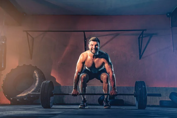Muskelkräftiger Fitnessmann, der in seiner Garage eine Langhantel über den Kopf schiebt, Selbstbefriedigung. Funktionstraining. Reißverschlussübung — Stockfoto
