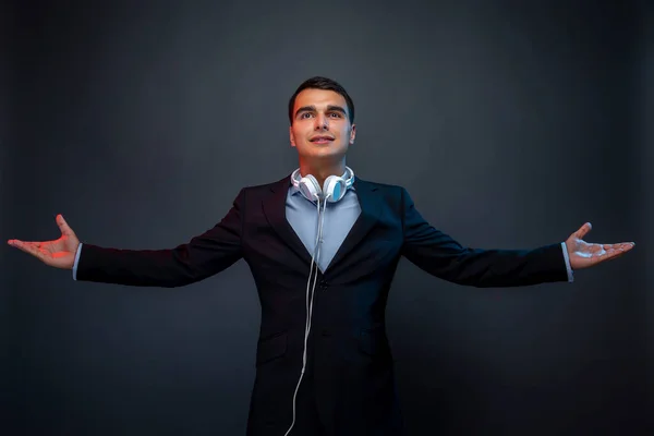 Portrait of man with headphones on dark background with smoke. Looking up. Studio shoot