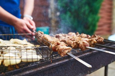 Metal şişte pişen ızgara kebap. Barbeküde pişmiş et. Barbekü taze et dilimleri. Geleneksel doğu yemeği, şiş kebap. Kömür ve alevler üzerine ızgara, piknik, sokak yemekleri