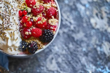 Yaz diyeti kahvaltısı için reçete fikirleri porsiyonlu çorba tabağında sağlıklı sabah tatlısı ahududu, kiraz, böğürtlen. Taş zeminde