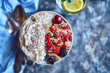 Yaz diyeti kahvaltısı için reçete fikirleri porsiyonlu çorba tabağında sağlıklı sabah tatlısı ahududu, kiraz, böğürtlen. Taş zeminde