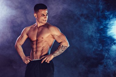 Stüdyoda kaslarını esneten atletik bir adam.