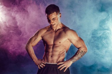 Stüdyoda kaslarını esneten atletik bir adam.