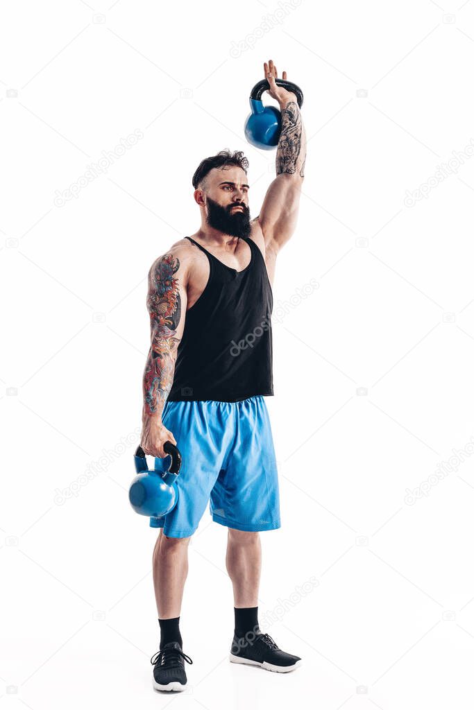 Muscular tattooed bearded male athlete bodybuilder workout with