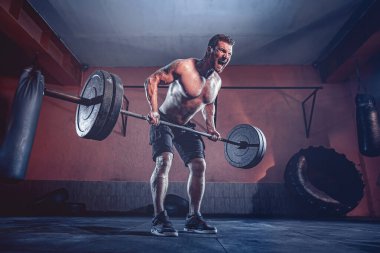 Spor salonunda egzersiz yapan kaslı bir adam. Güçlü erkek, çıplak karın kasları.