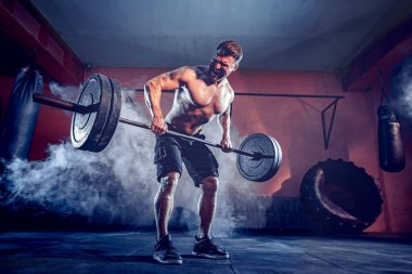 Spor salonunda egzersiz yapan kaslı bir adam. Güçlü erkek, çıplak karın kasları.