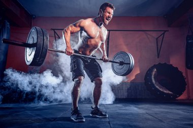 Spor salonunda egzersiz yapan kaslı bir adam. Güçlü erkek, çıplak karın kasları.