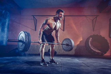 Spor salonunda egzersiz yapan kaslı bir adam. Güçlü erkek, çıplak karın kasları.