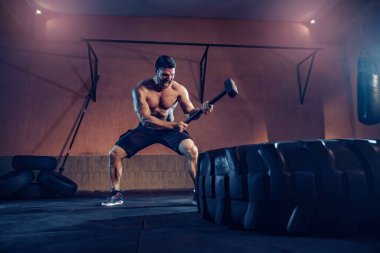 Dayanıklılık için spor eğitimi, adam çekice vuruyor. Kavram çalışması