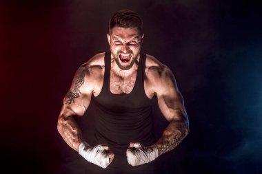 Sporcu Muay Thai boksörü siyah arka planda dumanla dövüşüyor. Spor konsepti