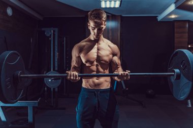 Sportif yong adam pazılar için ağır ağırlık egzersizi yapıyor.